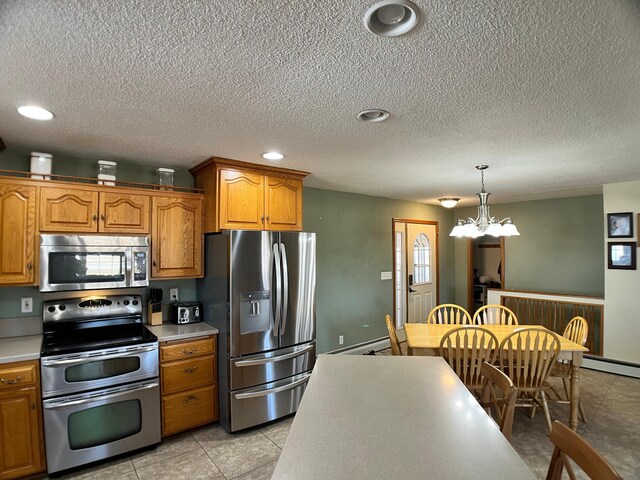 10306 Hemlock St NW, Annandale, MN 55302 - kitchen featuring stainless steel appliances, brown cabinets, light countertops, a baseboard radiator, and a textured ceiling