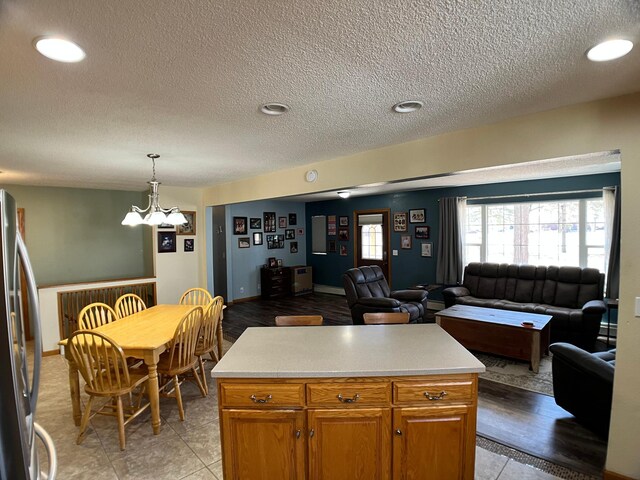 10306 Hemlock St NW, Annandale, MN 55302 - kitchen with freestanding refrigerator, open floor plan, light countertops, a textured ceiling, and a chandelier