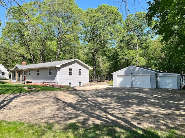 10306 Hemlock St NW, Annandale, MN 55302 - view of side of home with an outbuilding, a detached garage, a chimney, and view of scattered trees