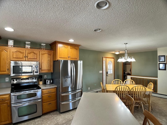 10306 Hemlock St NW, Annandale, MN 55302 - kitchen featuring appliances with stainless steel finishes, brown cabinets, light countertops, a baseboard radiator, and a textured ceiling