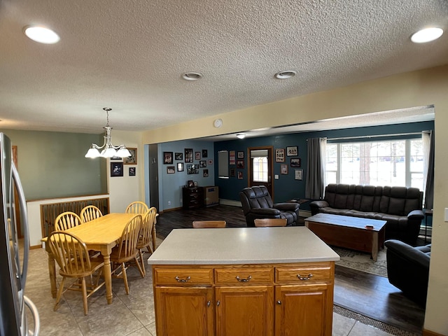 10306 Hemlock St NW, Annandale, MN 55302 - kitchen featuring freestanding refrigerator, open floor plan, light countertops, a textured ceiling, and hanging light fixtures