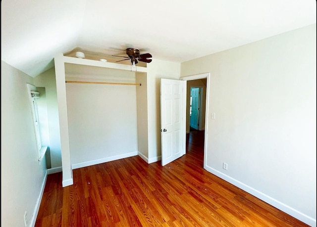 415 Francis St, Faribault, MN 55021 - unfurnished bedroom with wood finished floors, baseboards, a closet, and vaulted ceiling