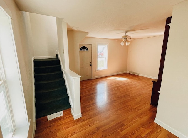 415 Francis St, Faribault, MN 55021 - unfurnished living room with a ceiling fan, wood finished floors, stairway, and baseboards