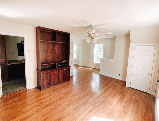 415 Francis St, Faribault, MN 55021 - unfurnished living room with ceiling fan, light wood finished floors, and baseboards