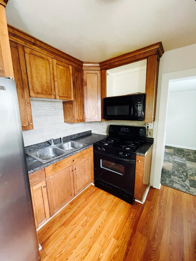 415 Francis St, Faribault, MN 55021 - kitchen featuring black appliances, a sink, decorative backsplash, dark countertops, and brown cabinets