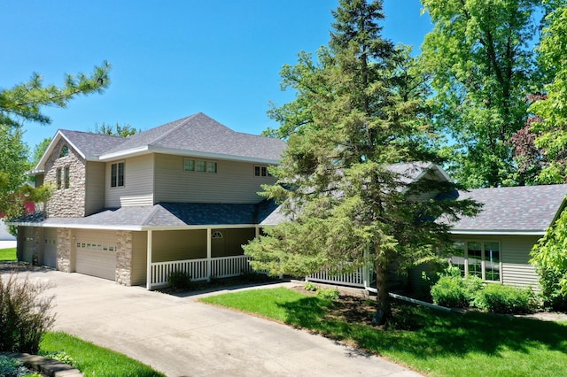 5386 165th St NE, Atwater, MN 56209 - view of front facade featuring stone siding, covered porch, concrete driveway, a garage, and a front yard