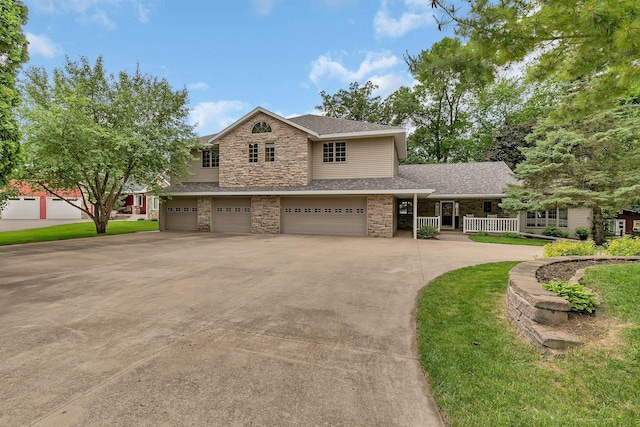 5386 165th St NE, Atwater, MN 56209 - traditional-style house featuring an attached garage, stone siding, driveway, roof with shingles, and covered porch