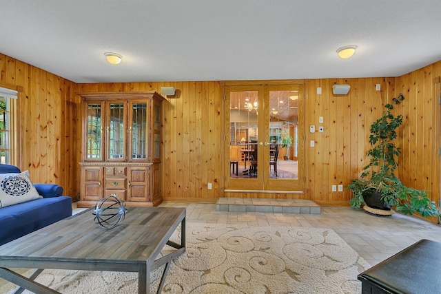 5386 165th St NE, Atwater, MN 56209 - living room featuring wooden walls, stone finish flooring, french doors, and baseboards
