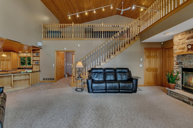 5386 165th St NE, Atwater, MN 56209 - carpeted living room featuring wooden ceiling, high vaulted ceiling, stairs, a fireplace, and baseboards