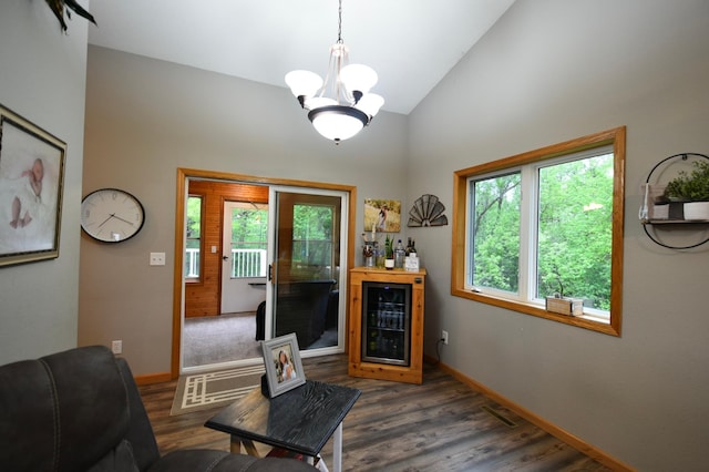201 Ridge Dr, Kenyon, MN 55946 - living area with wine cooler, dark wood-type flooring, vaulted ceiling, baseboards, and a chandelier