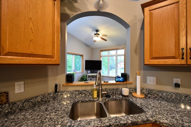 201 Ridge Dr, Kenyon, MN 55946 - kitchen with a sink, lofted ceiling, arched walkways, a ceiling fan, and dark stone countertops