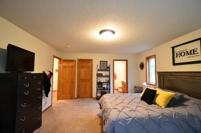 201 Ridge Dr, Kenyon, MN 55946 - bedroom featuring light colored carpet, a textured ceiling, and ensuite bath