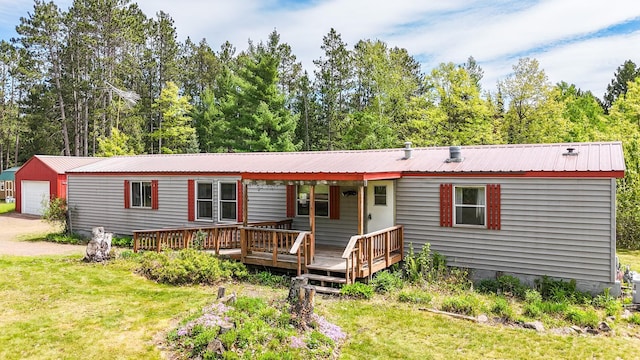3146 Green Bay Rd, Sturgeon Lake, MN 55783 - manufactured / mobile home with a front yard, metal roof, an outdoor structure, and a garage