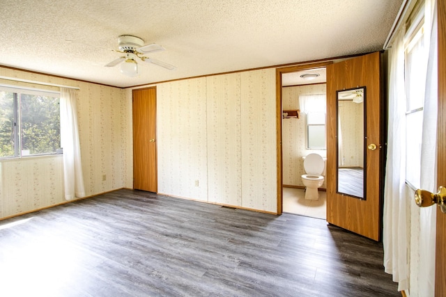 3146 Green Bay Rd, Sturgeon Lake, MN 55783 - unfurnished bedroom with wood finished floors, a textured ceiling, ensuite bathroom, wallpapered walls, and crown molding