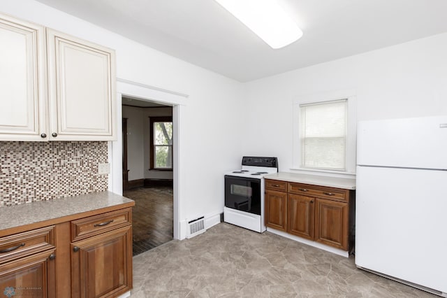 726 College St N, Fargo, ND 58102 - kitchen featuring freestanding refrigerator, electric range oven, backsplash, and brown cabinetry