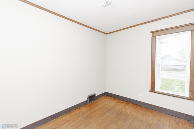 726 College St N, Fargo, ND 58102 - spare room with baseboards, light wood-type flooring, and crown molding
