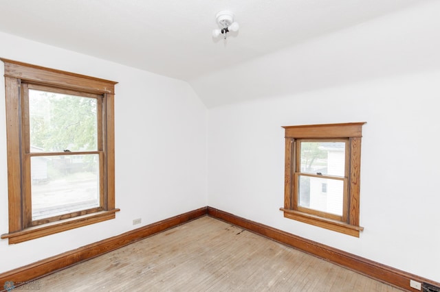 726 College St N, Fargo, ND 58102 - spare room with baseboards, lofted ceiling, and light wood-style flooring