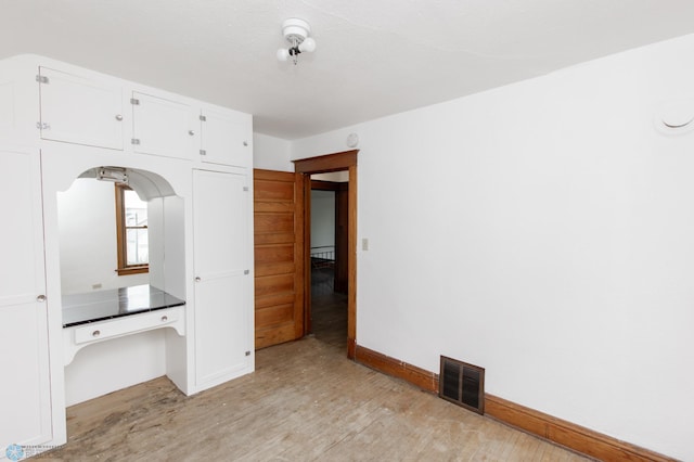 726 College St N, Fargo, ND 58102 - unfurnished bedroom with light wood-style flooring, baseboards, and baseboard heating