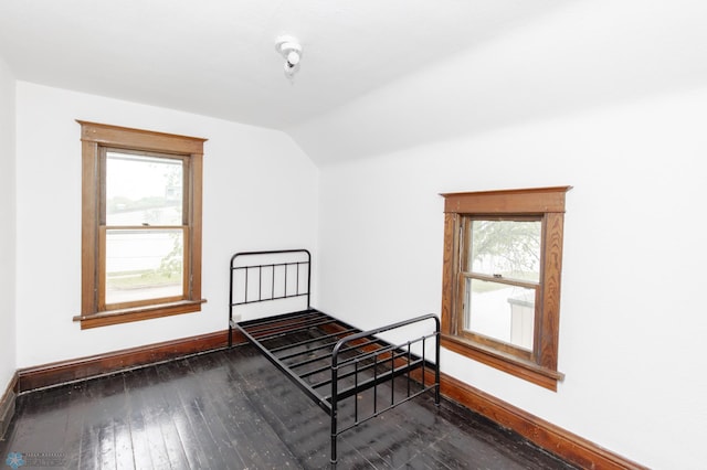 726 College St N, Fargo, ND 58102 - unfurnished bedroom featuring vaulted ceiling, wood-type flooring, multiple windows, and baseboards
