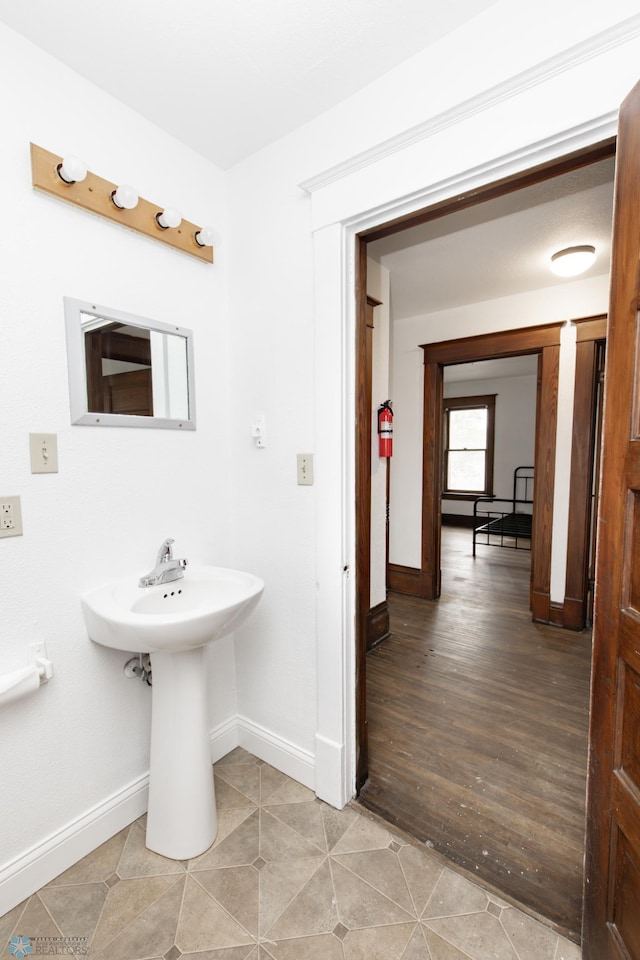 726 College St N, Fargo, ND 58102 - bathroom with baseboards, tile patterned floors, and a sink