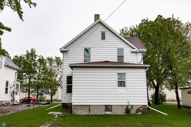 726 College St N, Fargo, ND 58102 - rear view of property with a chimney, a yard, and roof with shingles