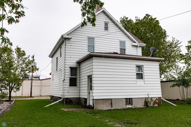 726 College St N, Fargo, ND 58102 - rear view of property featuring a yard and a chimney
