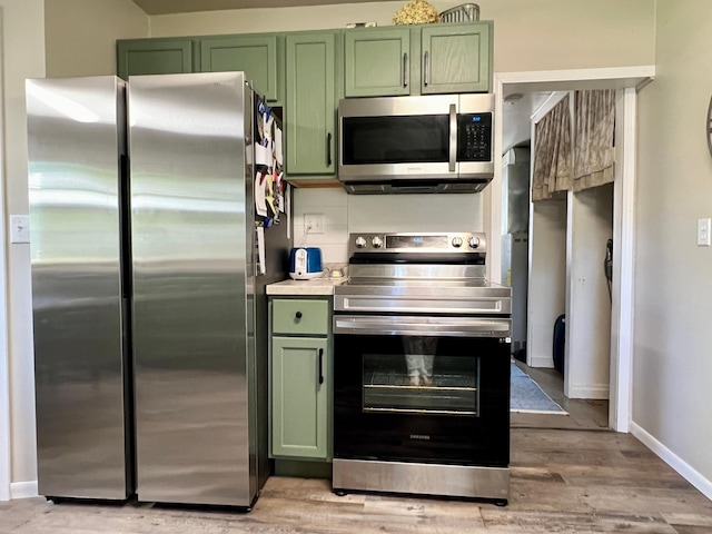 404 1st St S, Hoffman, MN 56339 - kitchen with green cabinets, stainless steel appliances, light wood-type flooring, and light countertops