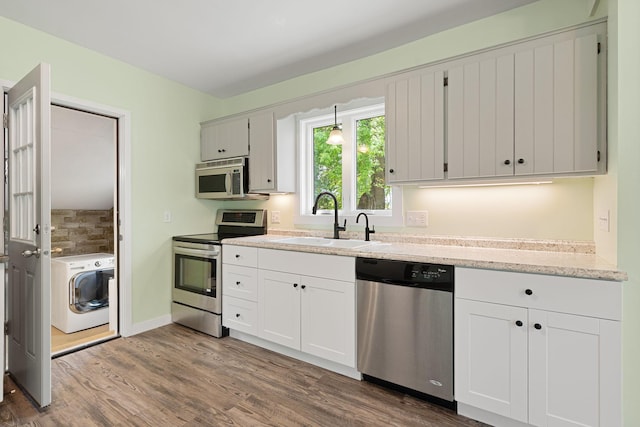 7149 92nd Ave SW, Lemond Twp, MN 56026 - kitchen with stainless steel appliances, a sink, washer / clothes dryer, dark wood finished floors, and white cabinets