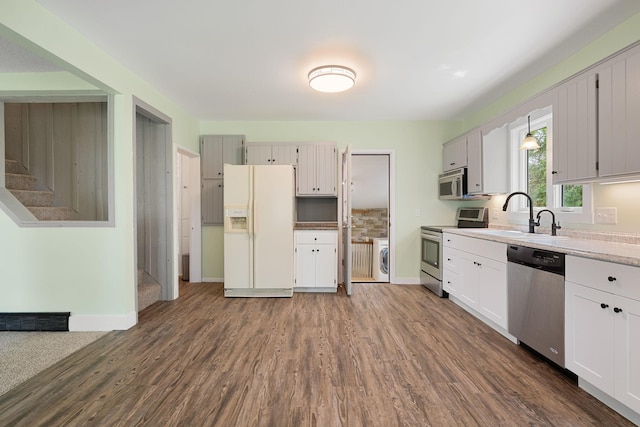 7149 92nd Ave SW, Lemond Twp, MN 56026 - kitchen with appliances with stainless steel finishes, a sink, dark wood-type flooring, baseboards, and light countertops