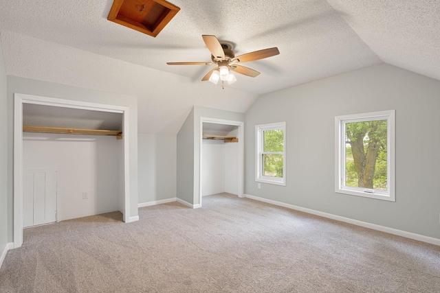7149 92nd Ave SW, Lemond Twp, MN 56026 - unfurnished bedroom featuring multiple closets, vaulted ceiling, carpet flooring, ceiling fan, and a textured ceiling