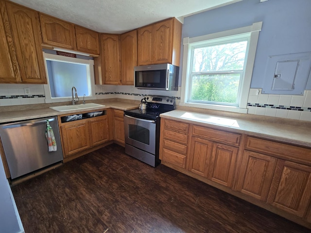 21824 County Highway 20, Lake Eunice Twp, MN 56501 - kitchen featuring appliances with stainless steel finishes, a sink, brown cabinets, tasteful backsplash, and a textured ceiling