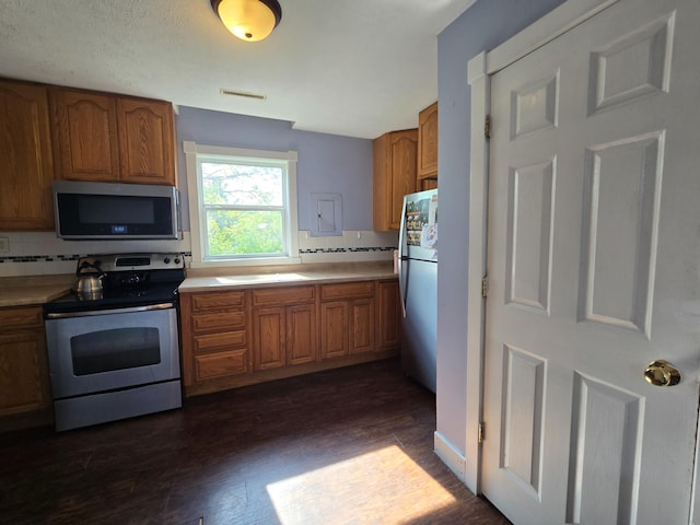 21824 County Highway 20, Lake Eunice Twp, MN 56501 - kitchen featuring stainless steel appliances, brown cabinetry, dark wood finished floors, light countertops, and backsplash