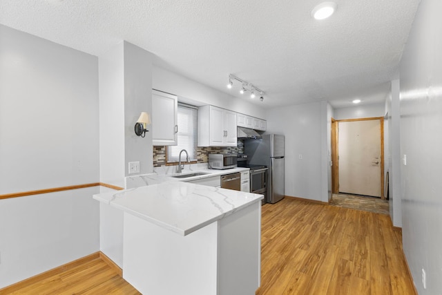 832 Woodgate Dr Unit 107, Vadnais Heights, MN 55127 - kitchen featuring a sink, stainless steel appliances, light wood-type flooring, white cabinets, and a textured ceiling