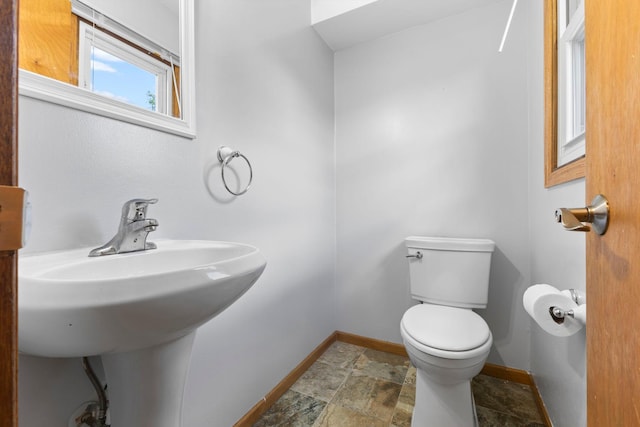 832 Woodgate Dr Unit 107, Vadnais Heights, MN 55127 - bathroom with toilet, baseboards, stone finish flooring, and a sink