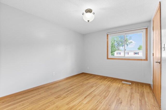 832 Woodgate Dr Unit 107, Vadnais Heights, MN 55127 - unfurnished room with light wood-type flooring and baseboards