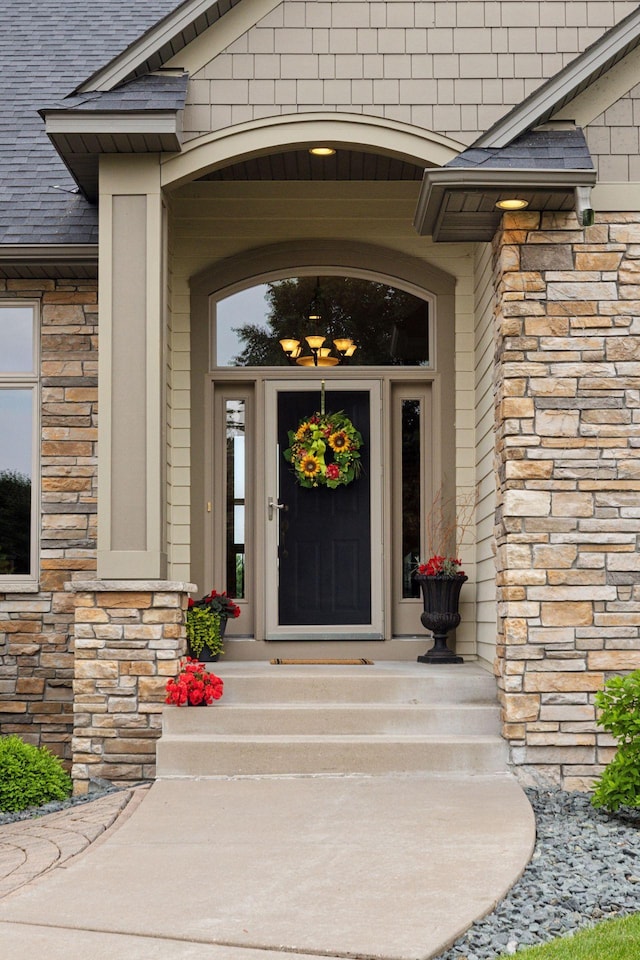 11565 Palisade Ct NE, Blaine, MN 55449 - property entrance with stone siding and a shingled roof