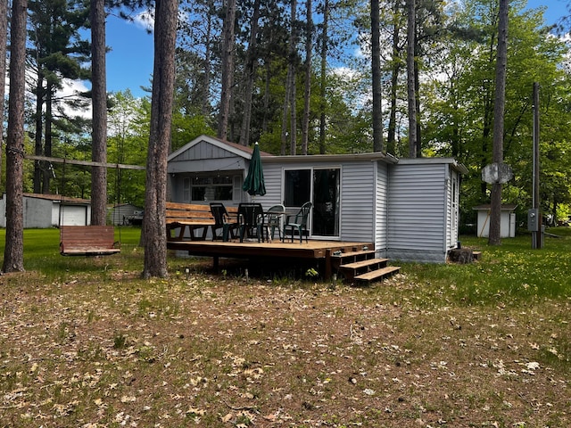 47114 188th Ave, Shamrock Twp, MN 55760 - back of property featuring a deck, view of scattered trees, and outdoor dining area