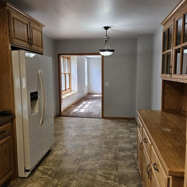 410 9th St, Morris, MN 56267 - kitchen with white fridge with ice dispenser, hanging light fixtures, baseboards, and stone finish flooring