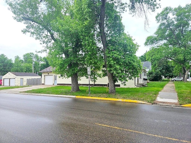 410 9th St, Morris, MN 56267 - view of property hidden behind natural elements with concrete driveway and a front lawn