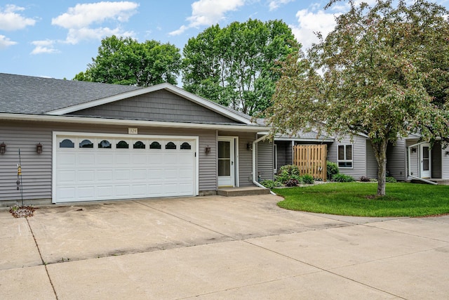 324 7th St NE, New Prague, MN 56071 - view of front facade featuring driveway, an attached garage, and a front lawn