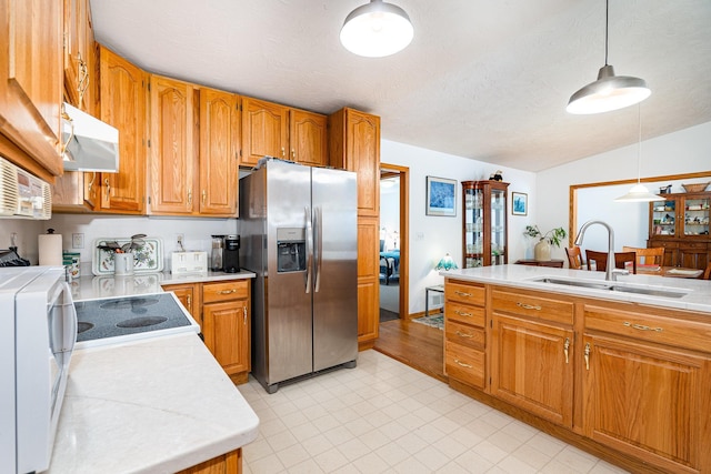 324 7th St NE, New Prague, MN 56071 - kitchen featuring stainless steel fridge, a sink, under cabinet range hood, light countertops, and vaulted ceiling