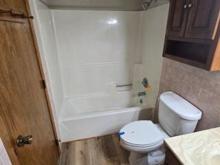 405 16th Ave NE, Waseca, MN 56093 - full bathroom with vanity, bathing tub / shower combination, toilet, and wood finished floors