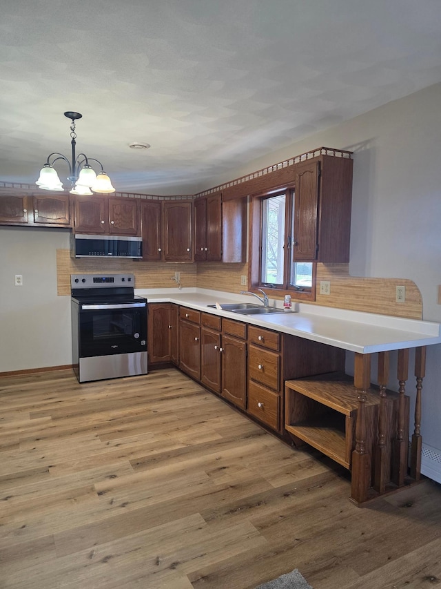 405 16th Ave NE, Waseca, MN 56093 - kitchen featuring stainless steel electric range oven, range hood, a sink, and light wood-type flooring