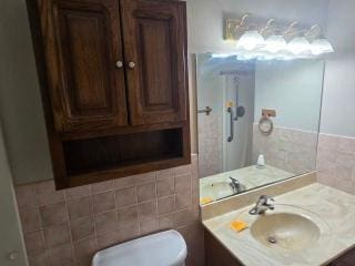 405 16th Ave NE, Waseca, MN 56093 - bathroom featuring vanity, toilet, and tile walls