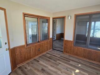 405 16th Ave NE, Waseca, MN 56093 - unfurnished room with a wainscoted wall, wooden walls, and wood finished floors