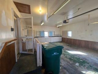 405 16th Ave NE, Waseca, MN 56093 - garage with a garage door opener, wainscoting, and wooden walls