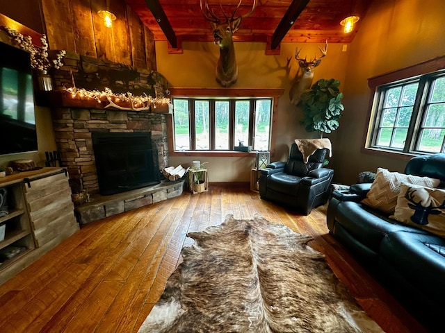 40580 Bow Trl, Nerstrand, MN 55053 - living area featuring a stone fireplace, wood-type flooring, and a wood ceiling with exposed beams