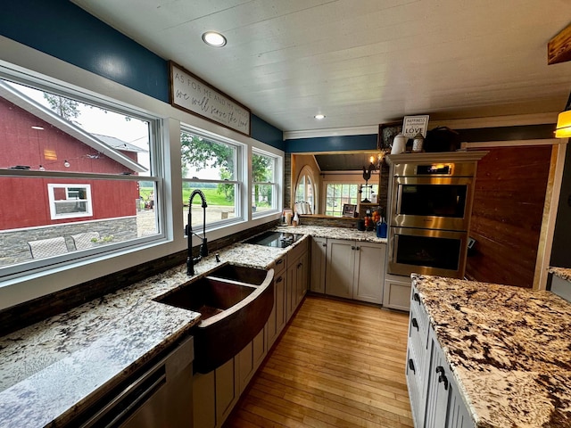 40580 Bow Trl, Nerstrand, MN 55053 - kitchen featuring appliances with stainless steel finishes, light wood-style flooring, light stone countertops, and recessed lighting