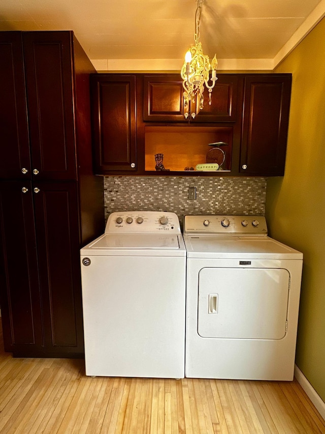 40580 Bow Trl, Nerstrand, MN 55053 - washroom featuring cabinet space, washing machine and dryer, light wood finished floors, and a chandelier