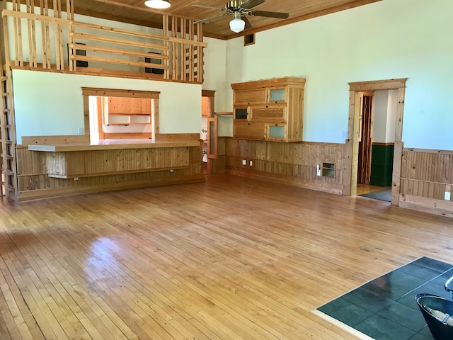 35379 215th Ave, Eagle Valley Twp, MN 56440 - unfurnished living room featuring a high ceiling, hardwood / wood-style flooring, a wainscoted wall, ceiling fan, and wood walls